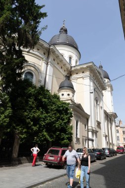 LVIV, UKRAINE - Haziran. 20, 2021: Ziyaretçiler büyüleyici mimari işaretler ve yemyeşil alanlarla dolu büyüleyici caddelerde gezinerek, Lviv 'in kültürel mirasını canlı bir ortamda sergiliyorlar..
