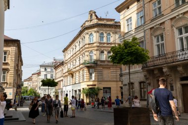 LVIV, UKRAINE - Haziran. 20, 2021: İnsanlar tarihi Lviv 'in canlı caddelerinde yürüyor, güzel mimari ve canlı şehir yaşamını sergiliyor, modernlikle zengin kültürel mirası harmanlıyor.