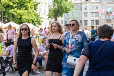 LVIV, UKRAINE - Haziran. 20, 2021: İnsanlar Lvivs tarihi bölgesinin caddelerinden geçiyor, canlı atmosferde ıslanıyorlar ve kafelerde ve dükkanlarda sıcak havanın tadını çıkarıyorlar..