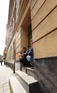 Lviv, Ukrayna - Haziran. 01, 2025: İki adam eski bir binanın önünde çömeliyor.