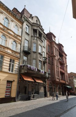 Lviv, Ukrayna - Haziran. 01, 2025: Şehrin mimarisinin özünü yansıtan tarihi binaların kaldırım taşı bir caddedeki manzarası.