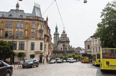 Lviv, Ukrayna - Haziran. 2001, 2025: Lviv 'de tarihi binalar, bir kilise ve bir kaldırım taşı yolunun yer aldığı bir sokak manzarası.