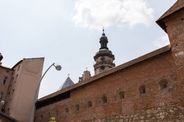 Lviv, Ukrayna - Haziran. 01, 2025: Bulutlu bir gökyüzüne karşı saat kulesi olan tarihi bir bina manzarası.