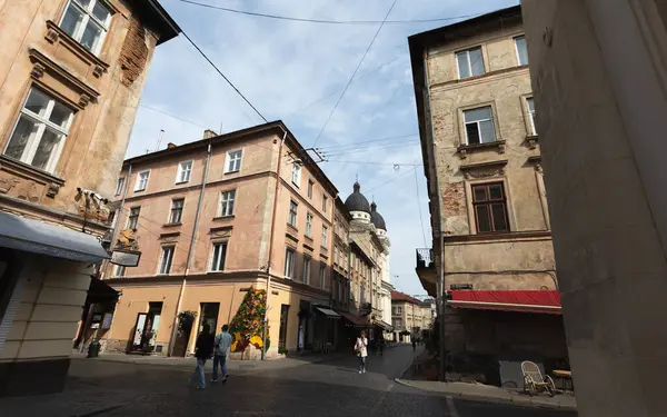 Lviv, Ukrayna - Haziran. 01, 2025: Lviv 'de tarihi bir caddenin aşağısında, eski binalar ve gezinen insanlarla dolu bir manzara.