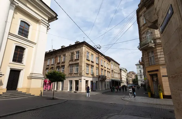 Lviv, Ukrayna - Haziran. 01, 2025: Lviv 'deki pitoresk bir sokak sahnesinde tarihi mimari sergileniyor, yayalarla dolup taşıyor ve kentsel yaşamın özünü yakalıyor.