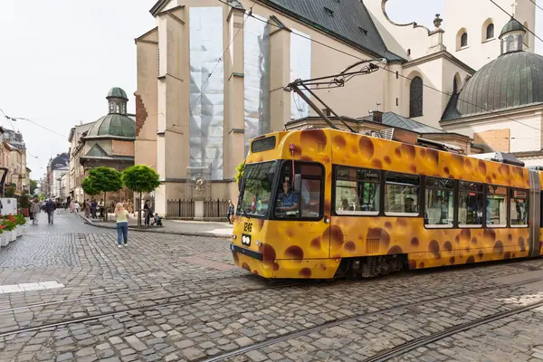 Lviv, Ukrayna - Haziran. 01, 2025: Eşsiz bir peynir temalı tramvay tarihi bir bölgede geziyor, şehir yaşamını gözler önüne seriyor.