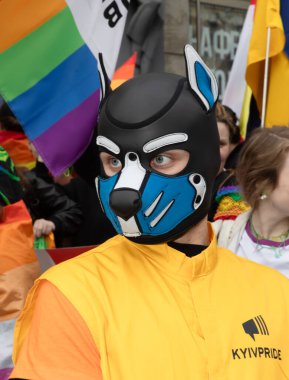 Kyiv, Ukrayna - Haziran. 14, 2025: KyivPride geçit töreninde köpek maskesi takan biri, arka planda gökkuşağı bayraklarıyla LGBTQ + haklarını kutluyor..