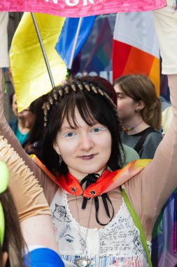 Kyiv, Ukrayna - Haziran. 14, 2025: Beyaz göz kalemi ve gökkuşağı pelerinli bir kişi Onur Yürüyüşü 'ne katılıyor,.