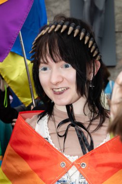 Kyiv, Ukrayna - Haziran. 14, 2025: KyivvPride yürüyüşünde gökkuşağı bayraklı, kurşun bantlı ve benzersiz makyajlı bir kişi, LGBTQ + haklarını kutluyor.