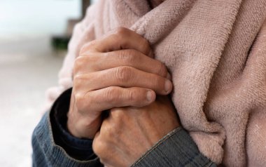 Yumuşak, pembe bir battaniye tutarak ellerinizi birbirine yaklaştırın. Kişi kot ceket giyiyor..