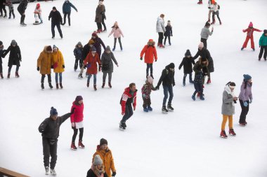 KYIV, UKRAINE - 27 Aralık 2020: buz pateni insanları. İnsanlar buz pateni sahasında eğleniyor. Kyiv 'de yeni yıl tatili.