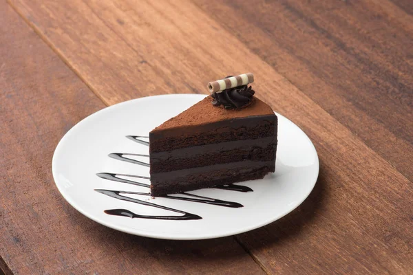 木製のテーブルの上のおいしいチョコレートケーキ — ストック写真