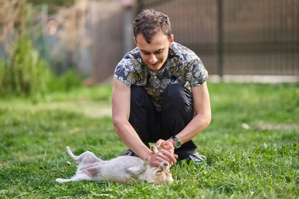Genç Adam Dışarıda Çimlerin Üzerinde Köpeğiyle Oynuyor — Stok fotoğraf