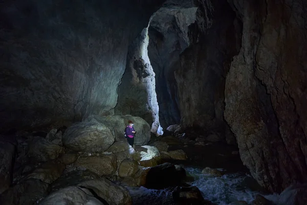 Sırt Çantalı Bir Kadın Nehirli Bir Mağaraya Giriyor — Stok fotoğraf