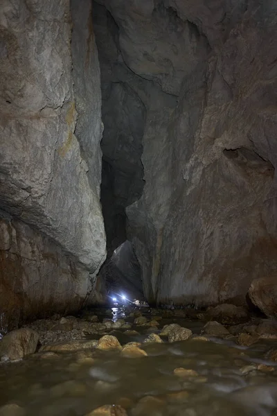 People with head lamps exploring the underground river and cave