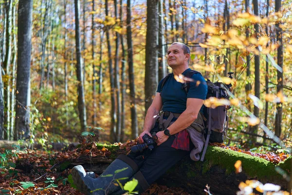 带着沉重背包在山毛榉林中小径上远足的自然摄影师 — 图库照片