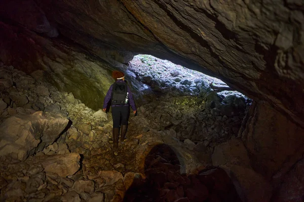 Sırt Çantalı Bir Kadın Yeraltındaki Bir Mağaraya Giriyor — Stok fotoğraf