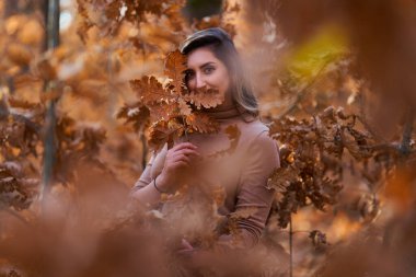 Ayrıca sonbaharın sonlarında meşe ormanında güzel bir kadın.