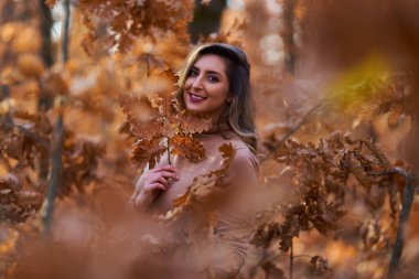 Ayrıca sonbaharın sonlarında meşe ormanında güzel bir kadın.