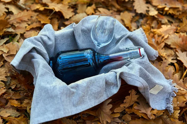 Butelka Czerwonego Wina Skrzyni Ręcznik Opadłych Liściach Lesie — Zdjęcie stockowe