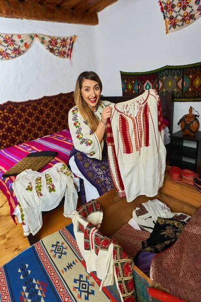Молода Румунська Жінка Відкриває Скриню Багатьма Традиційними Костюмами — стокове фото