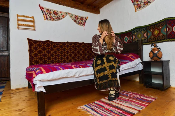 在一个传统的乡村家庭里 年轻的罗马尼亚女人穿着传统的流行服装 图库图片