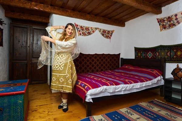 年轻的罗马尼亚女人穿着传统的新娘流行服装在一个古老的家 — 图库照片