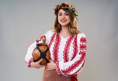 Gri arka planda soyutlanmış, geleneksel Rumen kostümlü genç bir kadın.