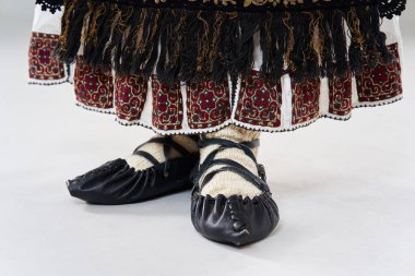 Gri arka planda soyutlanmış, geleneksel Rumen kostümlü genç bir kadın.