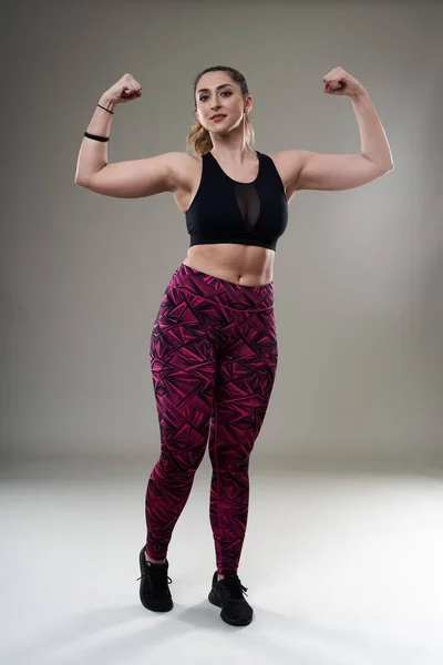 Młoda Size Latynoska Kobieta Pozująca Stroju Fitness Szarym Tle Akceptacja — Zdjęcie stockowe