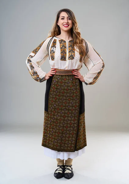 人気のヴィンテージ伝統的なルーマニアの衣装で若い女性 灰色の背景に隔離されました ロイヤリティフリーのストック画像
