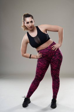 Kendine güveni tam, vücut ısısı yüksek, çalışmadan önce esneme hareketleri var. Gri arka planda izole edilmiş.