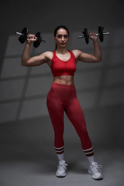 Sportliche Junge Fitnessmodel Frau Roten Fitnessstudio Outfit Beim Training Studiobeleuchtung — Stockfoto