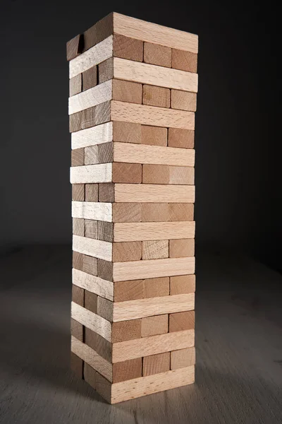 Stack of wooden blocks in a game of Jenga on a table