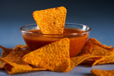 Mavi tahta üzerinde salsa soslu Meksika cipsi.