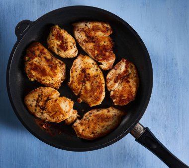 Seared chicken breast pieces in a non stick frying pan
