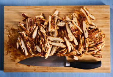 Roasted sliced chicken breast on a wooden board, ready to prepare fajitas