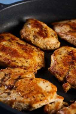 Seared chicken breast pieces in a non stick frying pan
