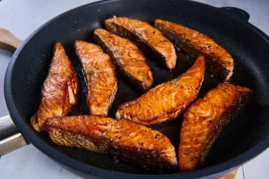 Salmon fillets in the frying pan, after cooking, seared and juicy