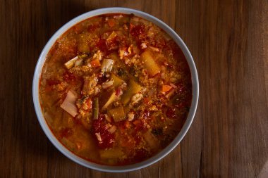 Leek and tomatoes soup on a wooden board
