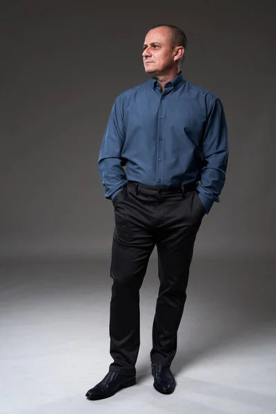 自信に満ちた成熟したビジネス男で正式なスーツフル長さ上の灰色の背景 スタジオショット — ストック写真