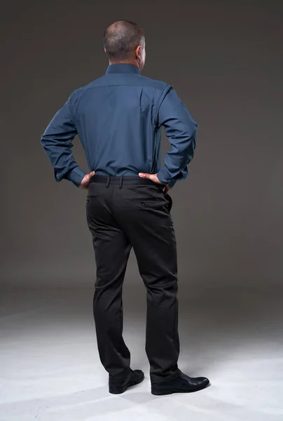 Full body portrait of a mature businessman seen from the back