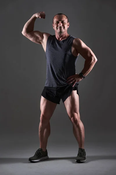 一个成熟男子在灰色背景下做健身锻炼的全身照 — 图库照片