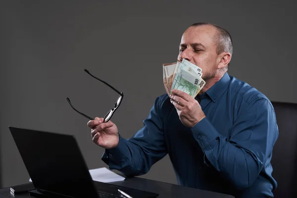 快乐成熟的商人拥有现金 坐在他的办公桌前 概念上的财富 好的收入 — 图库照片