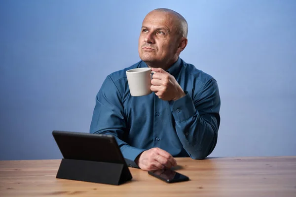 Взрослый Бизнесмен Пьет Кофе Своим Столом Перед Планшетом — стоковое фото