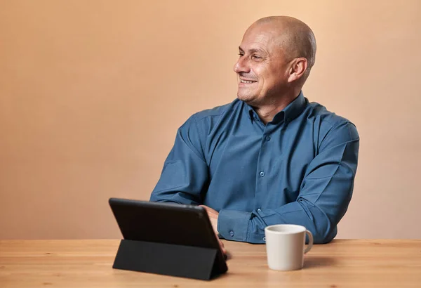 Szczęśliwy Dojrzały Biznesmen Siedzi Przy Biurku Mając Telefon Tablet Filiżankę — Zdjęcie stockowe