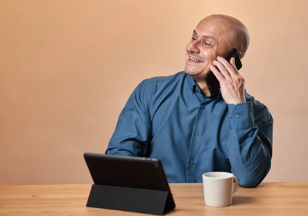 Šťastný Veselý Podnikatel Svého Stolu Tabletem Kávou Mluví Mobilním Telefonu — Stock fotografie