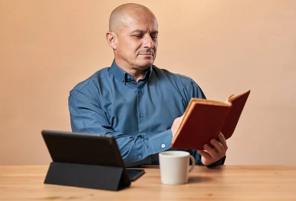 Зрелый Бизнесмен Читающий Книгу Перерыве Кофе Рабочим Столом Заднем Плане — стоковое фото