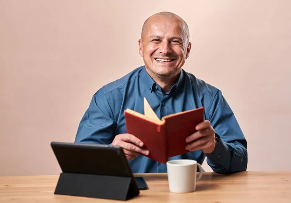 Άνθρωπος Διαβάζει Ένα Χιουμοριστικό Βιβλίο Ενώ Είναι Στο Γραφείο Του — Φωτογραφία Αρχείου