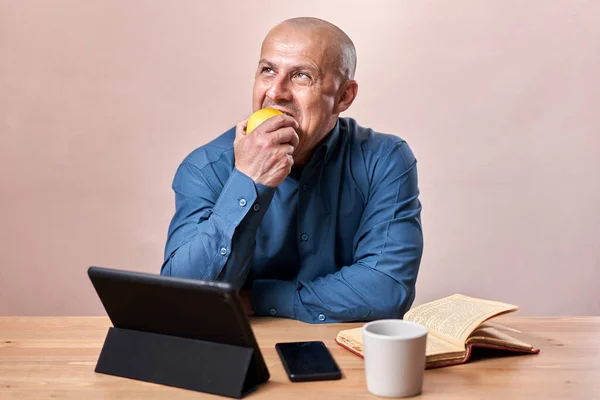 ビジネスマンは机で仕事の休憩中にリンゴを食べる — ストック写真